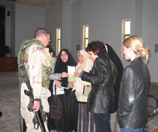 February 2004. The Women's Rights Center in Karbala. Fern Holland, far right and Salwa Oumashi, second from right, pointing to the picture, were killed in Iraq in March 2004.